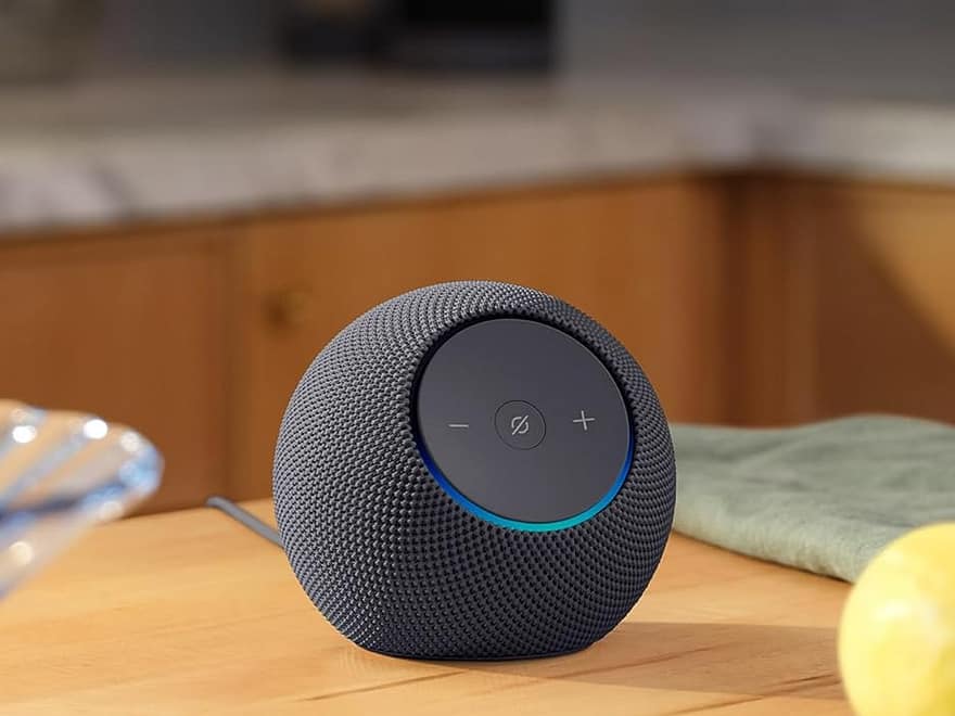 Echo Dot Max Alexa speaker, dark fabric spherical design with top buttons and LED ring, placed on wooden kitchen counter