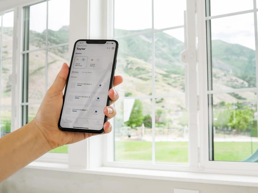 MySmartWindows Retrofit Kit app control shown on a smartphone beside white smart window openers